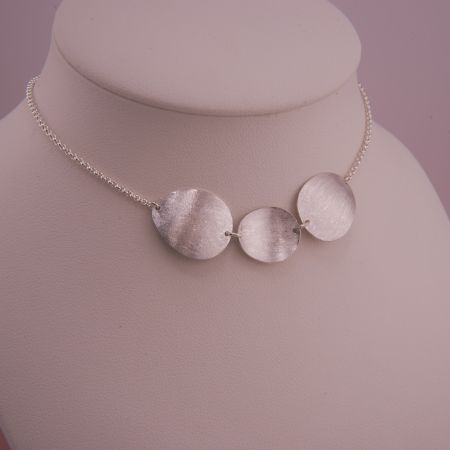 Nahaufnahme des Isola Colliers im Floating Look, kurz am Hals dekoriert, zur Veranschaulichung der optimalen Passform.